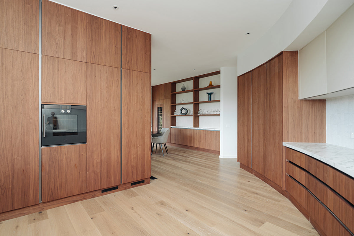 Long run of warm wood-grain cabinets in a contemporary interior